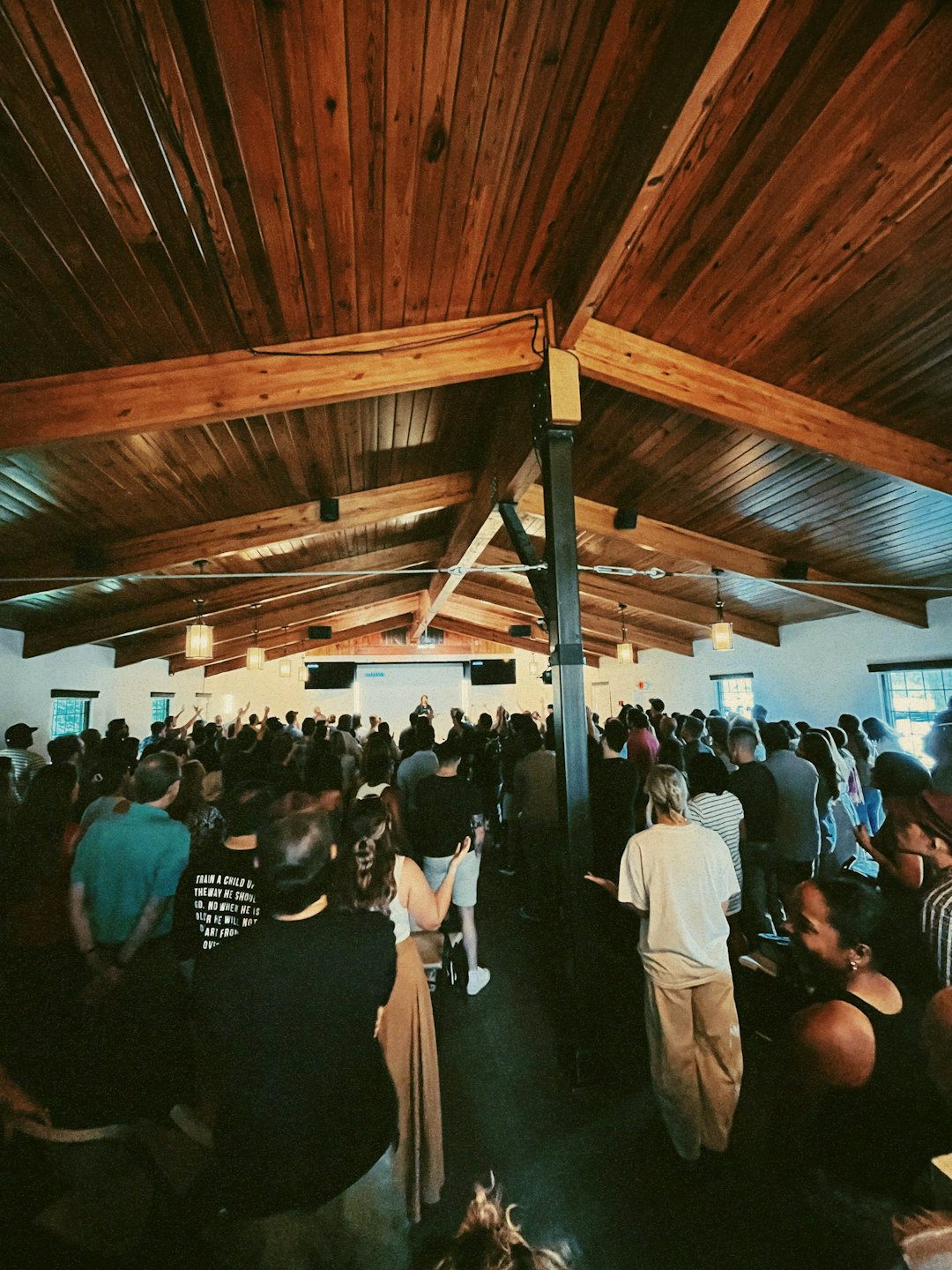 People raise their hands during a conference in a hall.