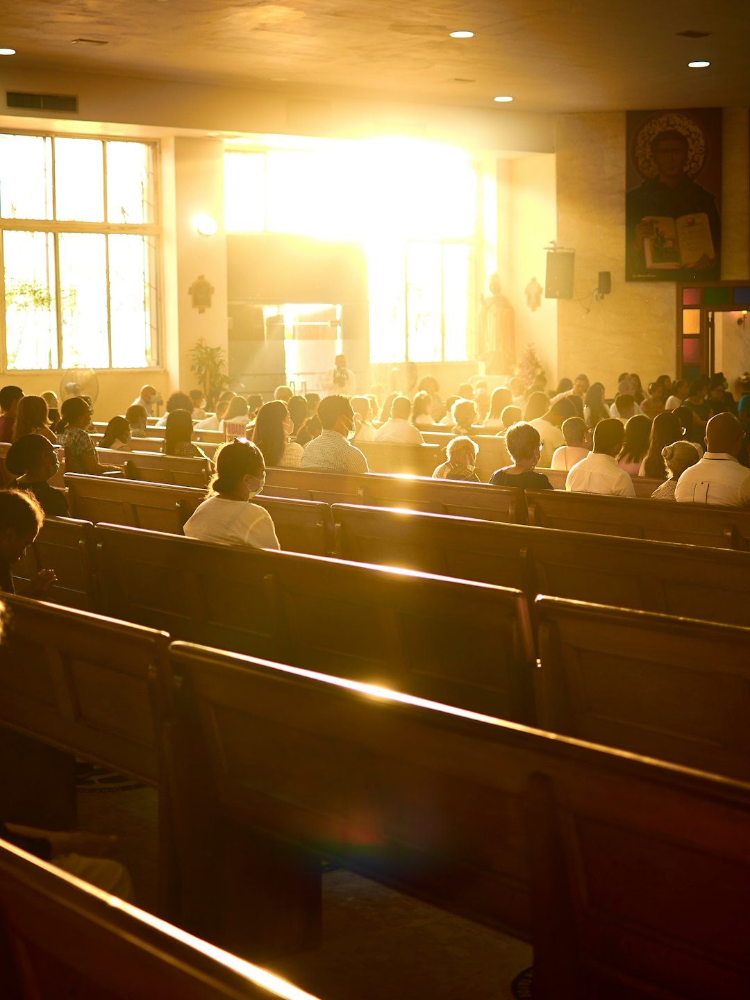 People sit in wooden pews during a church service.
